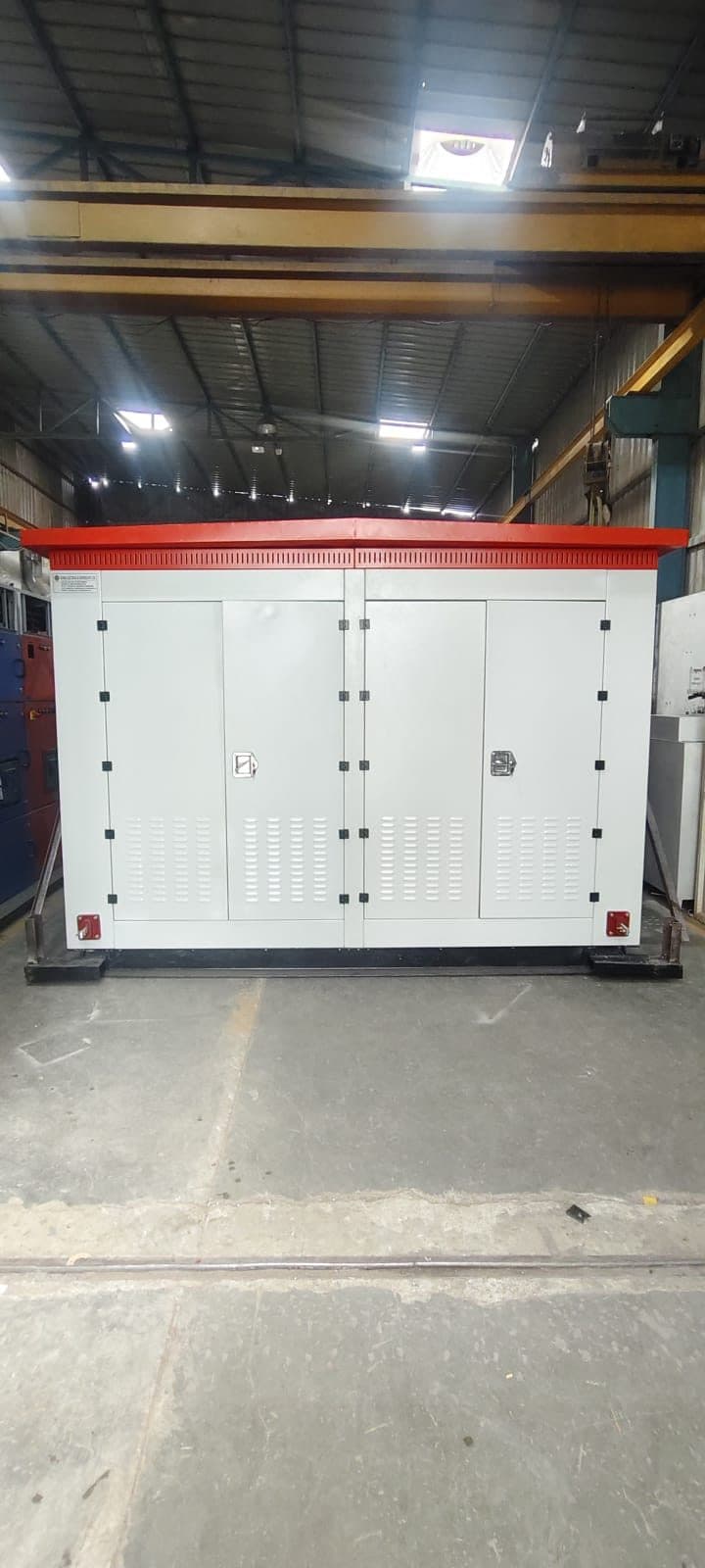 Package substation enclosure with a red roof on the shop floor