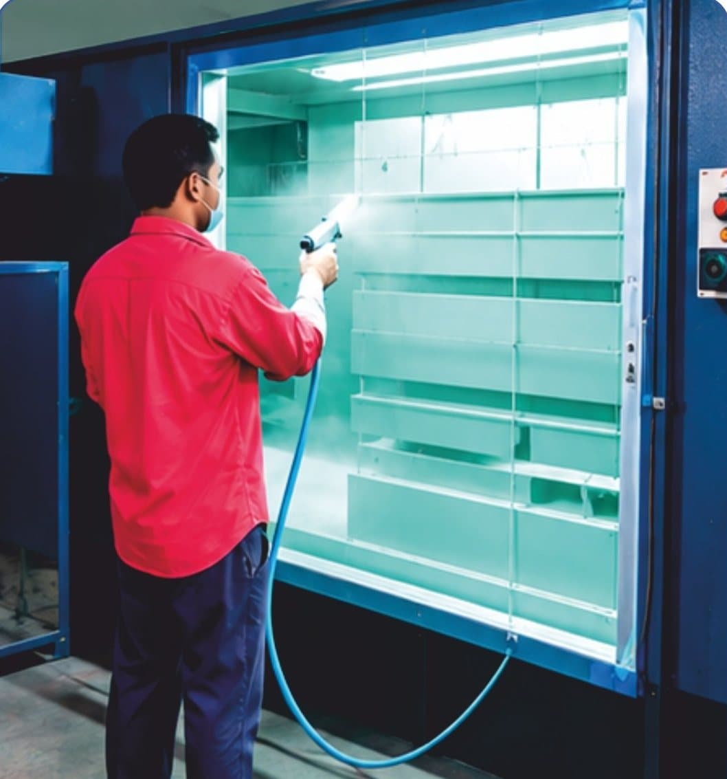 Technician powder coating panel parts in the spray booth